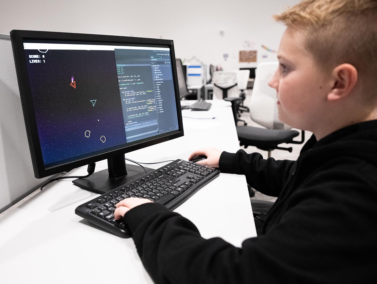 Young boy coding a video game at a computer