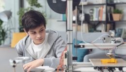 Young boy working with a 3D printer